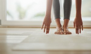 Elevation Med Spa Lone Tree Colorado woman doing yoga touching the ground with straight legs